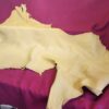 Yellow leather hide on red fabric background.
