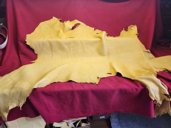 Yellow leather hide on red fabric background.