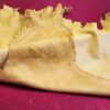 Yellow leather hide on red surface.