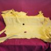 Yellow leather hide on red fabric background.