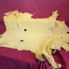 Yellow animal hide on red fabric background.