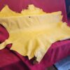 Yellow animal hide on red fabric background.