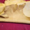 Tan leather hide on red fabric background.