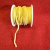 Yellow suede cord spool on red fabric.