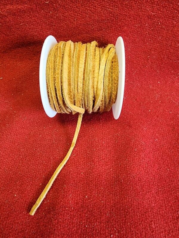 Brown leather cord spool on red fabric.