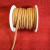Brown suede cord spool on red fabric.