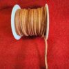Brown leather cord spool on red fabric.