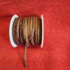 Brown leather cord spool on red fabric.