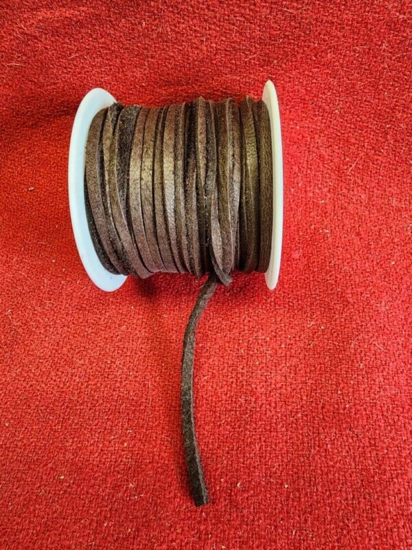Brown leather cord spool on red fabric.