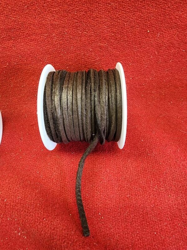 Brown leather cord spool on red background.