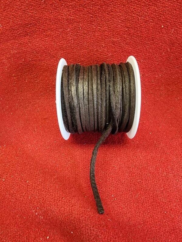 Spool of black leather cord on red.