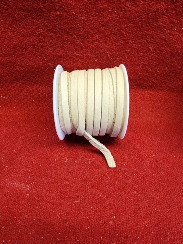 Beige cord spool on red background.