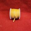 Orange leather cord spool on red background.