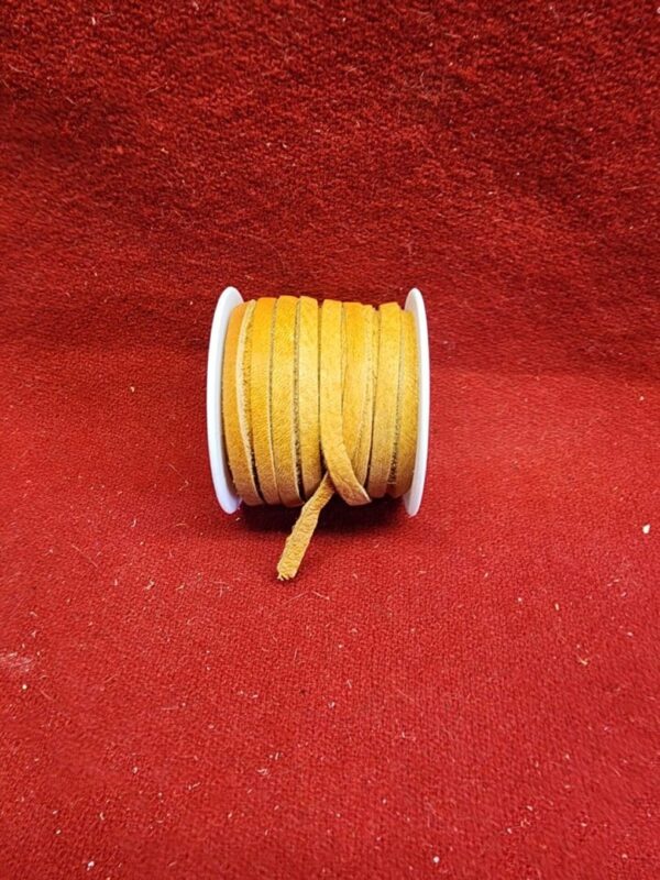 Orange leather cord spool on red background.