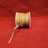 Brown leather cord spool on red fabric.