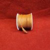 Brown suede cord spool on red background.