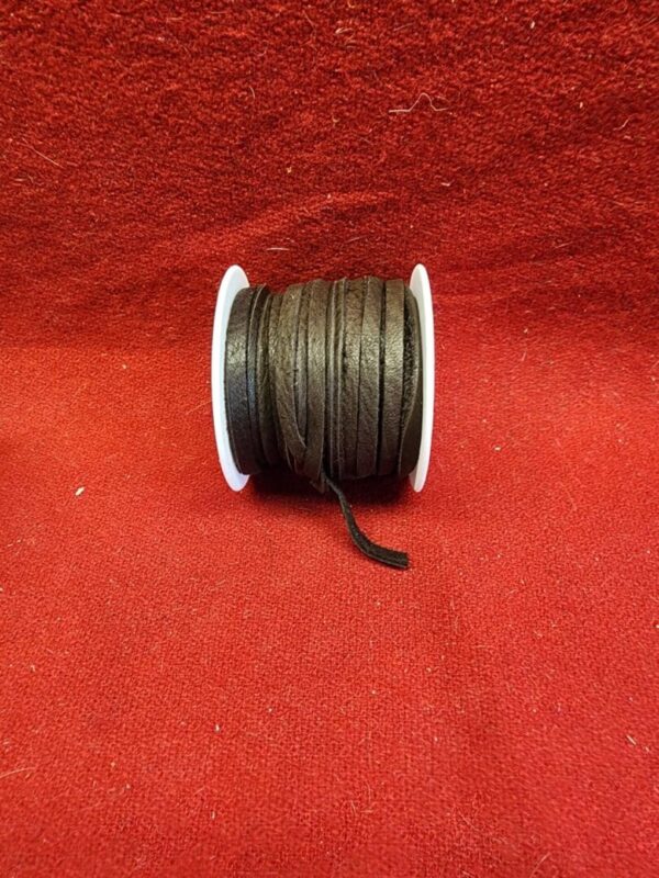 Brown leather cord spool on red fabric.