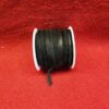 Black ribbon spool on red textured background.
