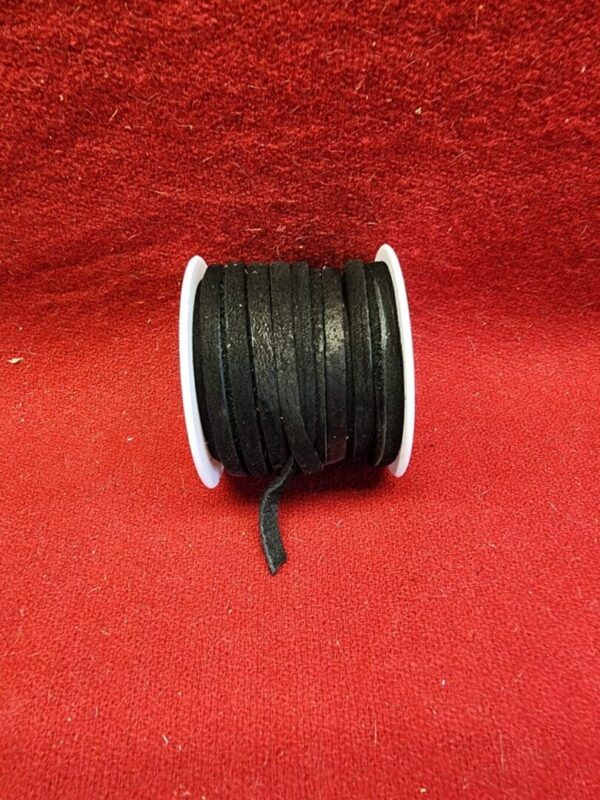 Black ribbon spool on red textured background.