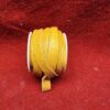 Yellow leather cord on red fabric background.