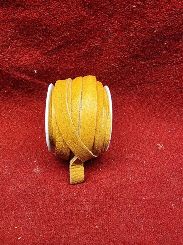Yellow leather cord on red fabric background.