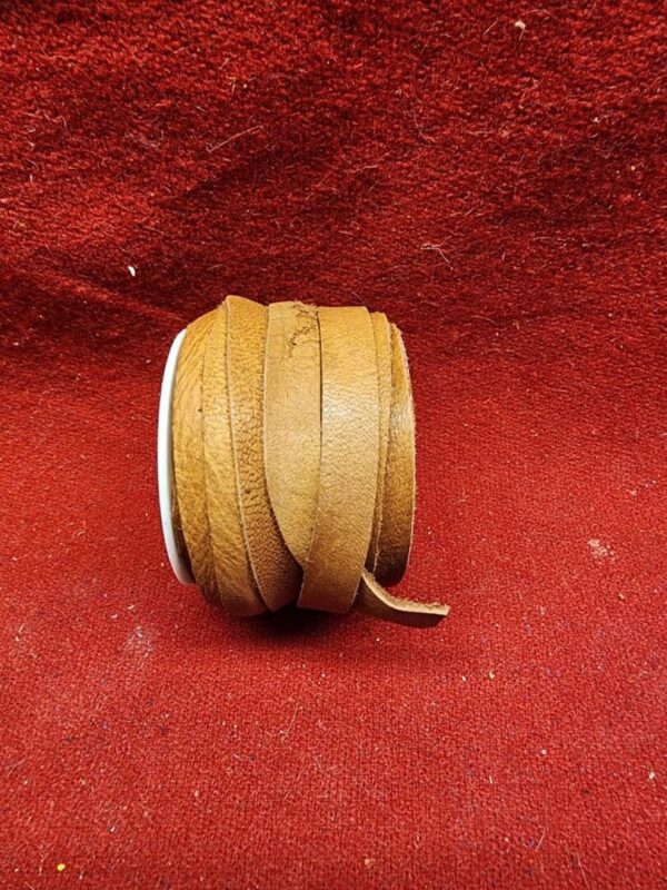 Brown leather lace roll on red background.