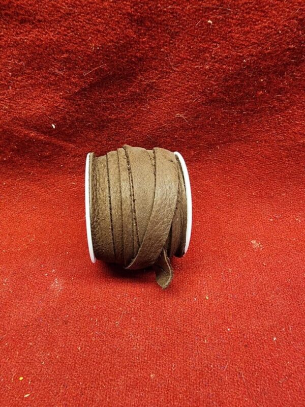 Brown leather cord spool on red fabric.