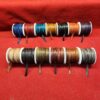 Colorful spools of leather cords on display.