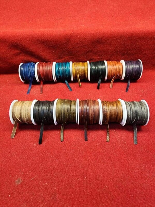 Colorful spools of leather cords on display.