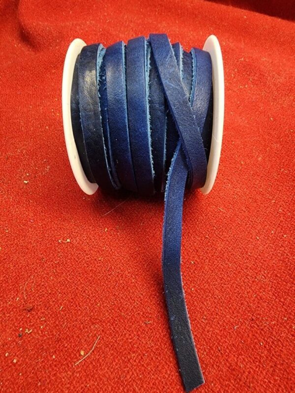 Blue ribbon spool on red fabric background.