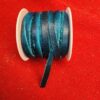 Blue ribbon spool on red fabric background.