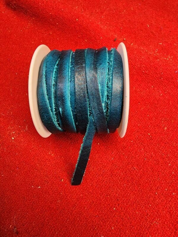 Blue ribbon spool on red fabric background.