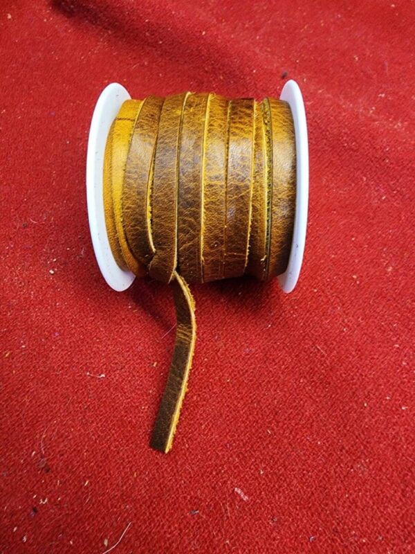 Brown leather cord spool on red fabric.