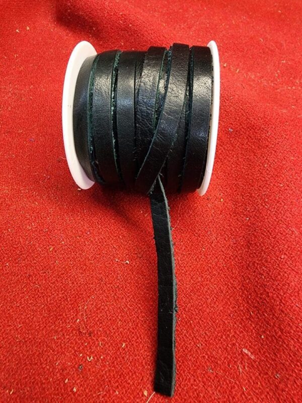 Black leather cord on red fabric background.