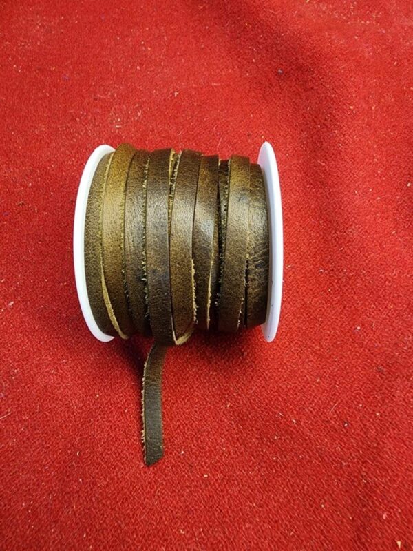 Brown leather cord spool on red fabric.