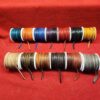 Colorful spools of thread on red fabric.