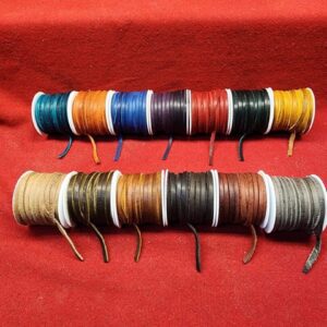 20240110_183014 Colorful spools of thread on red fabric.