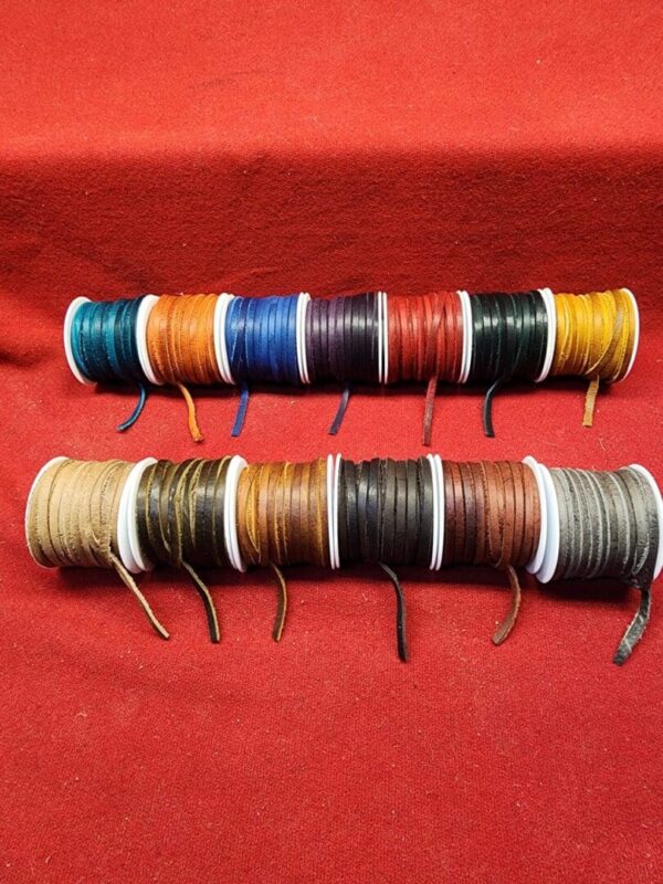 Colorful spools of thread on red fabric.