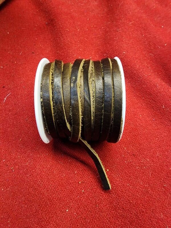 Brown leather cord spool on red fabric.