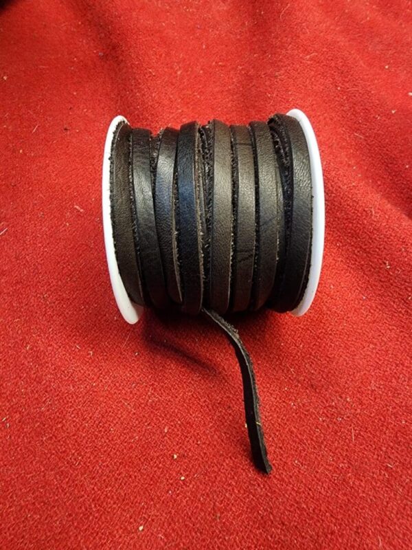 Roll of black leather strips on red.