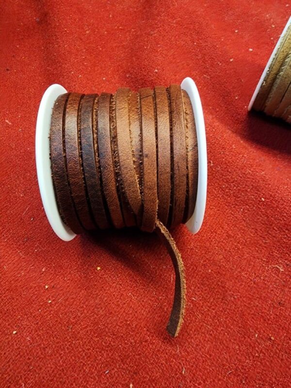 Brown leather strips on white spool.