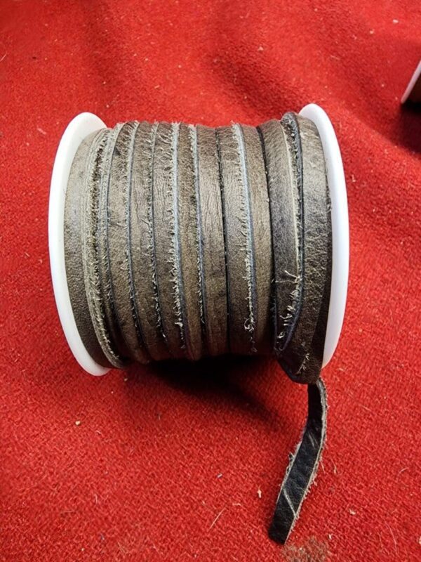 Roll of brown leather straps on spool.