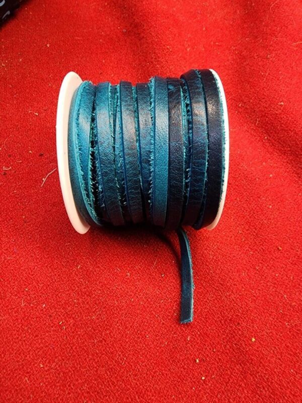 Blue leather cord spool on red fabric.