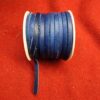Blue leather cord spool on red fabric.
