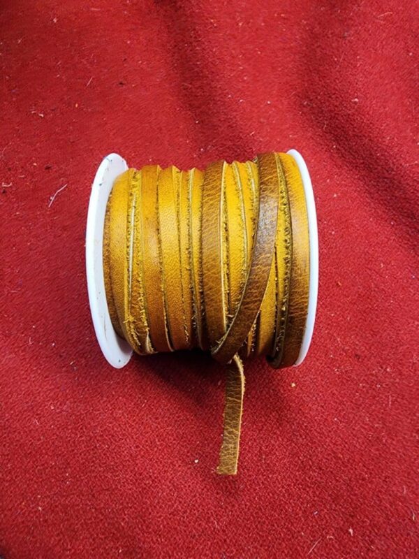 Brown leather cord spool on red fabric.