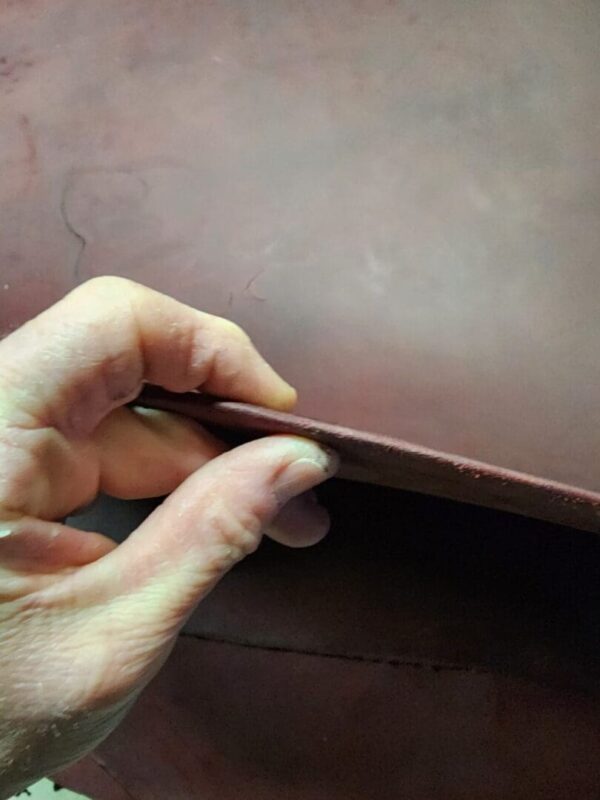 20240215_180113 - Copy Hand holding a piece of leather.