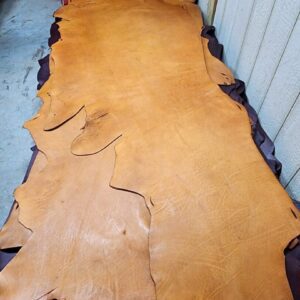 20240215_180319 Tanned leather hide on a workshop table.