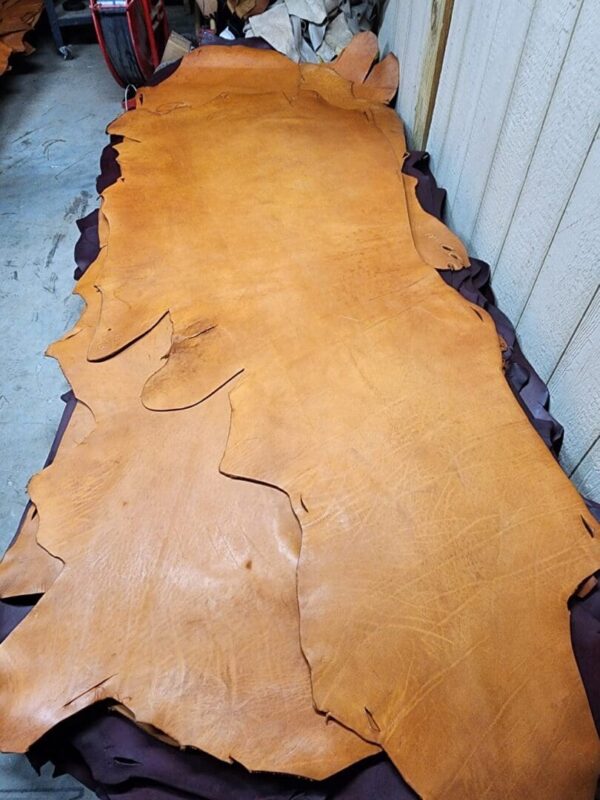 Tanned leather hide on a workshop table.