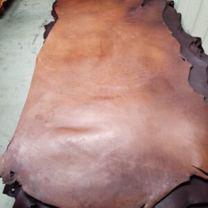 20240215_180547 Brown leather hides stacked on floor.