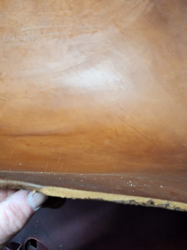 20240215_180559 Holding a piece of brown leather material.